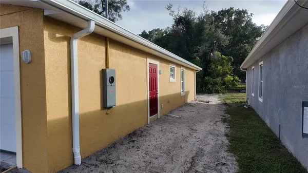 a view of a house with backyard and trees