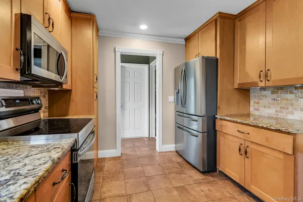 a kitchen with stainless steel appliances granite countertop a refrigerator stove and cabinets