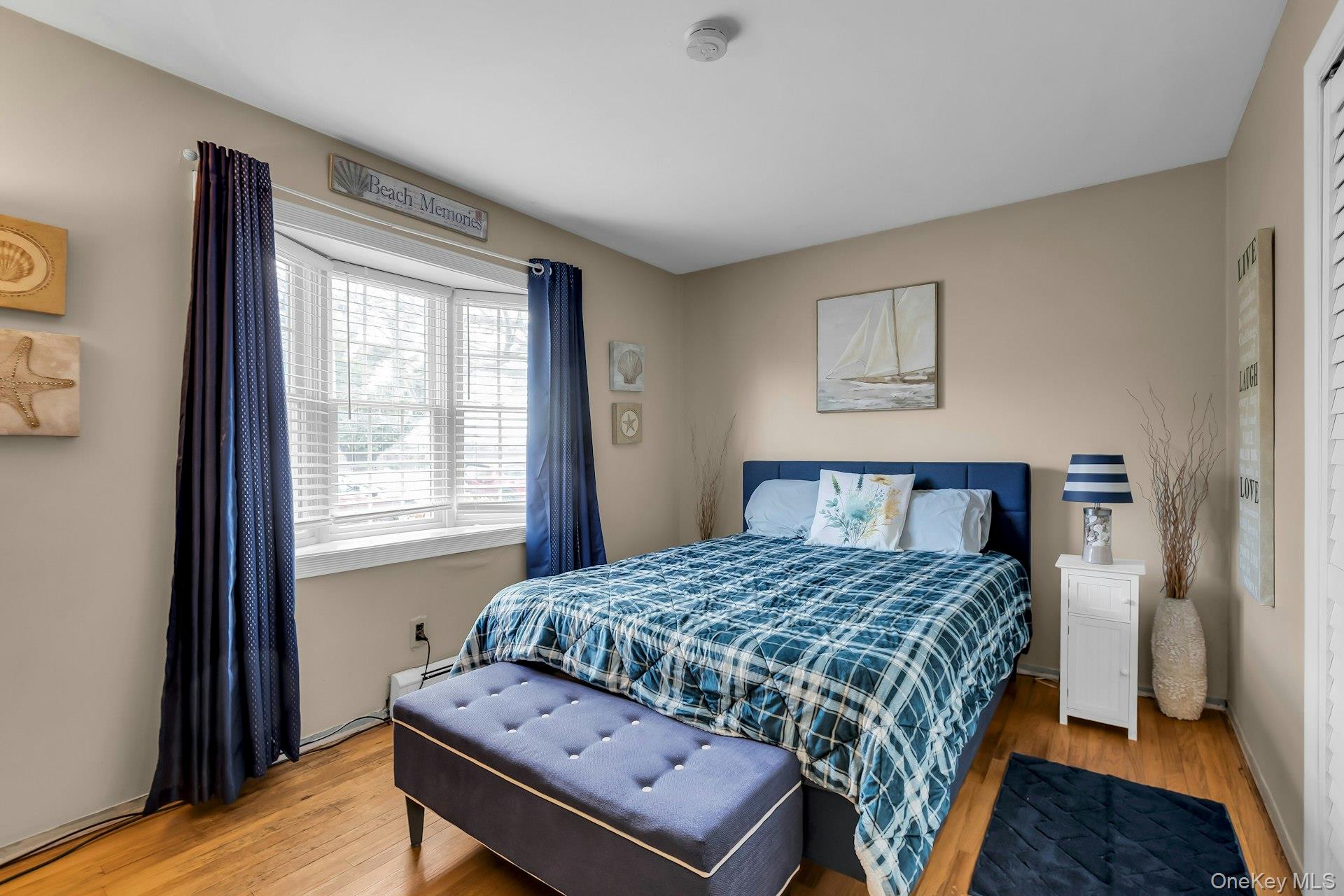 358 Rider Avenue Patchogue, NY 11772 - Photo 16 of 25 Bedroom with light wood finished floors and a baseboard heating unit