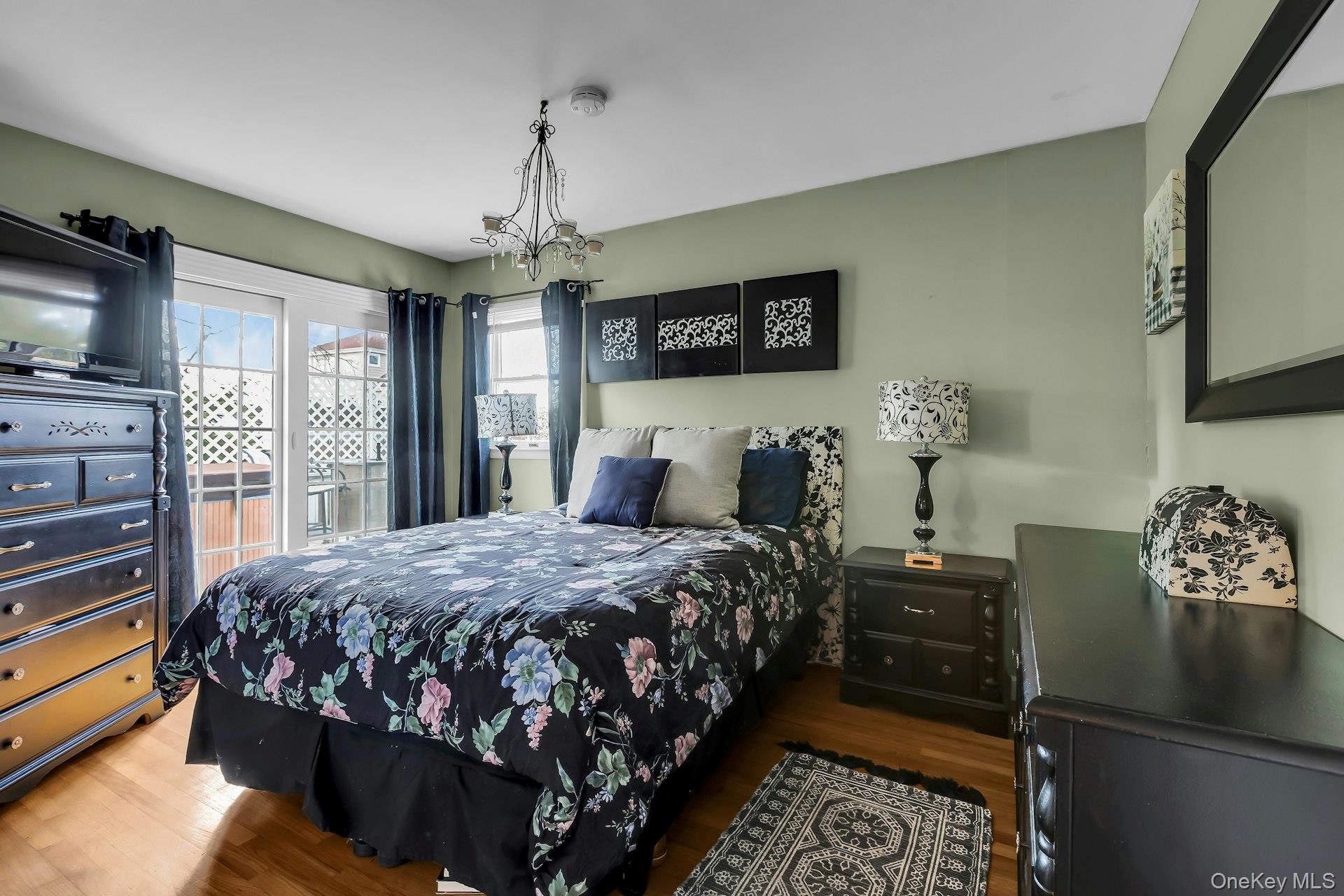 358 Rider Avenue Patchogue, NY 11772 - Photo 18 of 25 Bedroom featuring wood finished floors and a chandelier