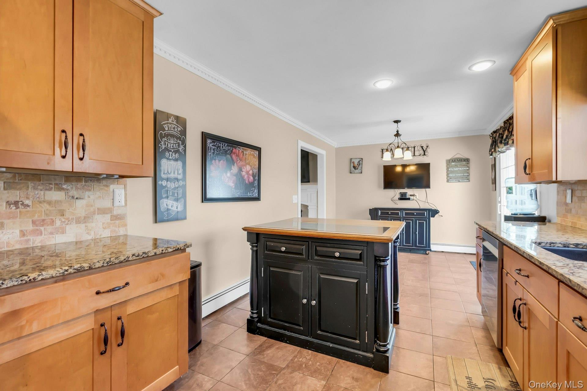 358 Rider Avenue Patchogue, NY 11772 - Photo 10 of 25 Kitchen featuring backsplash, dark cabinetry, light stone countertops, ornamental molding, and a baseboard heating unit