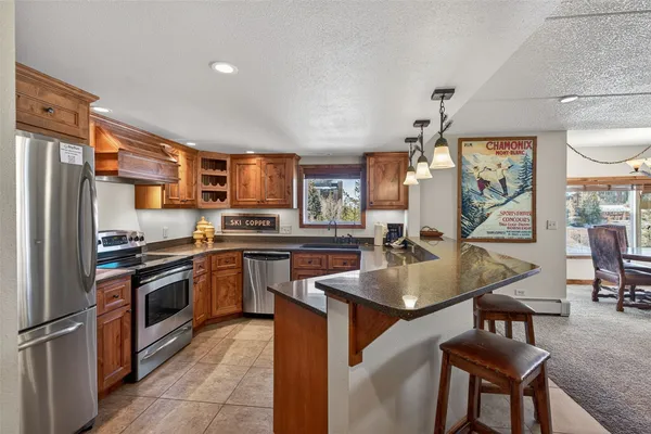 a kitchen with stainless steel appliances granite countertop a refrigerator and a sink