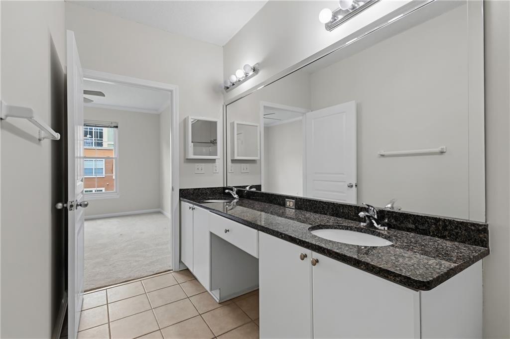 10 Perimeter Summit Boulevard, Unit 3311 Atlanta, GA 30319 - Photo 62 of 68 a bathroom with a granite countertop sink a mirror and a shower