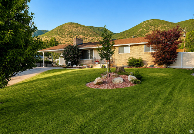 1020 Wilmar Place Centerville, UT 84014 - Photo 1 of 22 Brick ranch-style residence featuring a carport, established landscaping, and a fenced side yard