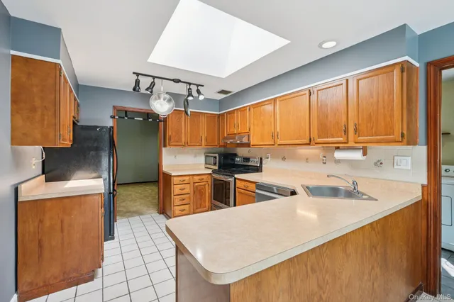a kitchen with stainless steel appliances a sink and a refrigerator