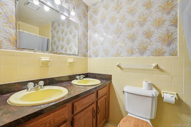 a bathroom with a sink mirror vanity and toilet