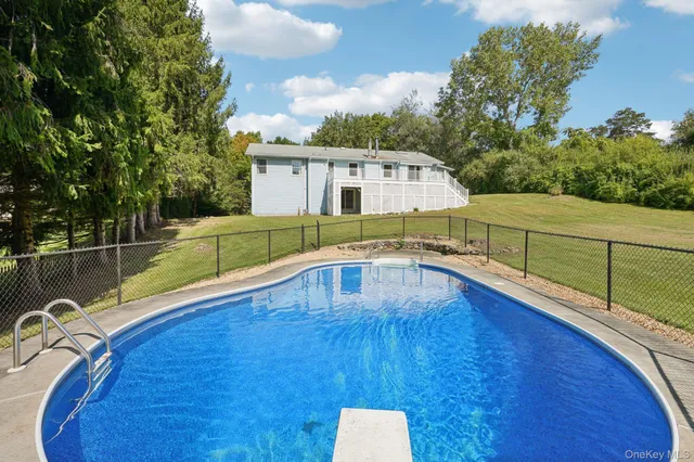 a view of a swimming pool with a chair and floor to ceiling window