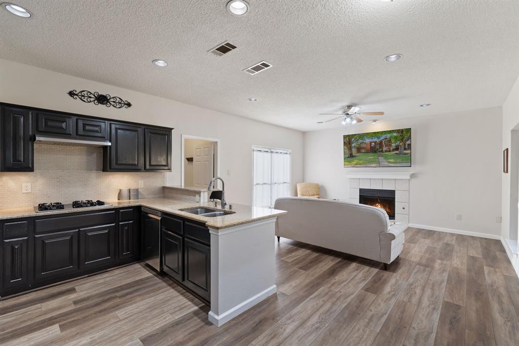 750 Pulitzer Lane Allen, TX 75002 - Photo 13 of 40 a kitchen with stainless steel appliances granite countertop a sink stove and wooden floor