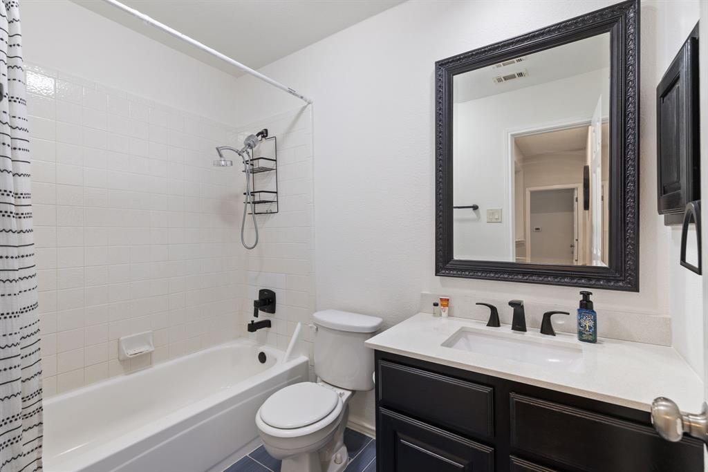 750 Pulitzer Lane Allen, TX 75002 - Photo 19 of 40 a bathroom with a granite countertop sink toilet a mirror and bathtub