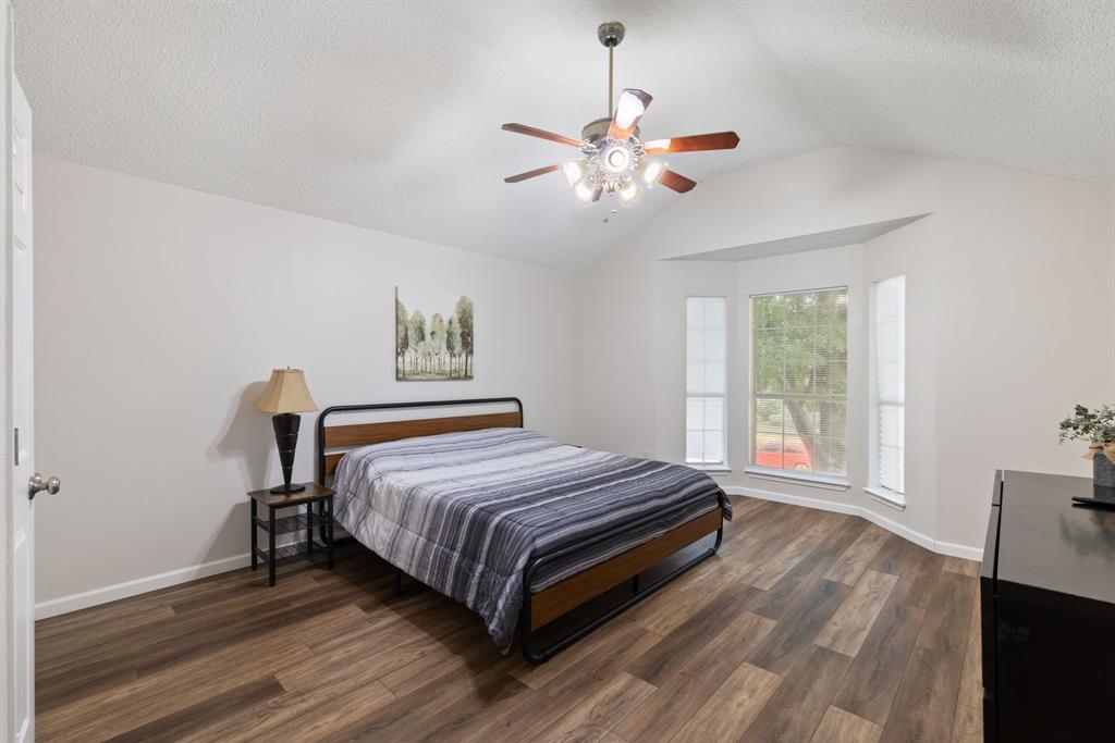 750 Pulitzer Lane Allen, TX 75002 - Photo 20 of 40 a bedroom with a bed and a chandelier