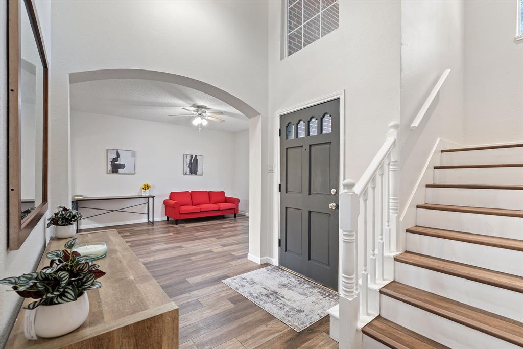 750 Pulitzer Lane Allen, TX 75002 - Photo 8 of 40 a view of a hallway with a dining table chairs and couches with wooden floor