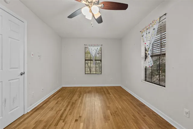 a view of empty room with wooden floor