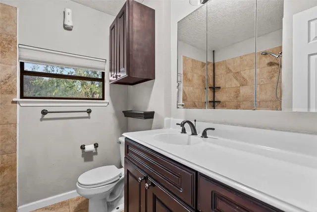 a bathroom with a sink a toilet and shower