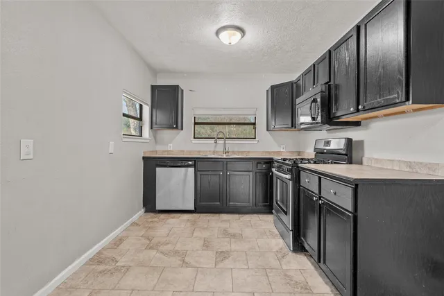 a kitchen with stainless steel appliances granite countertop a stove sink and cabinets