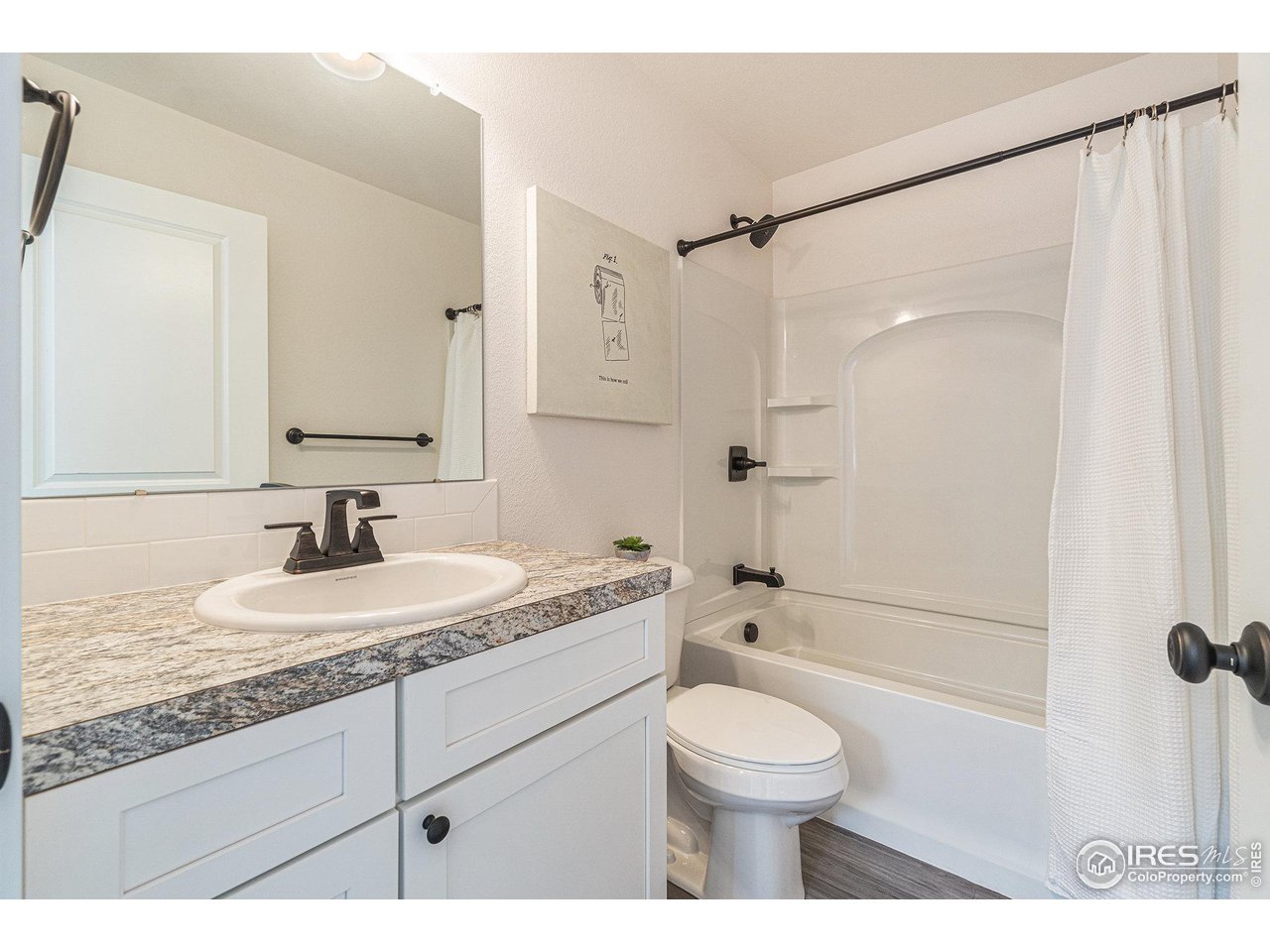 2771 Red Wheat Trail Berthoud, CO 80513 - Photo 17 of 24 a bathroom with a granite countertop sink toilet a shower and a mirror