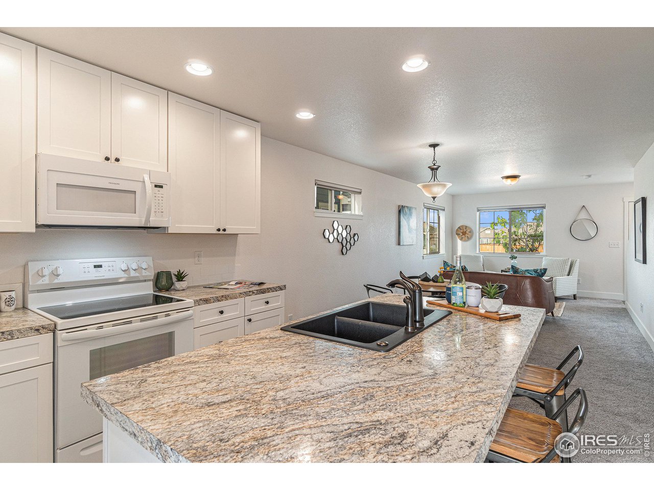 2771 Red Wheat Trail Berthoud, CO 80513 - Photo 8 of 24 a kitchen with stainless steel appliances kitchen island granite countertop a sink and cabinets