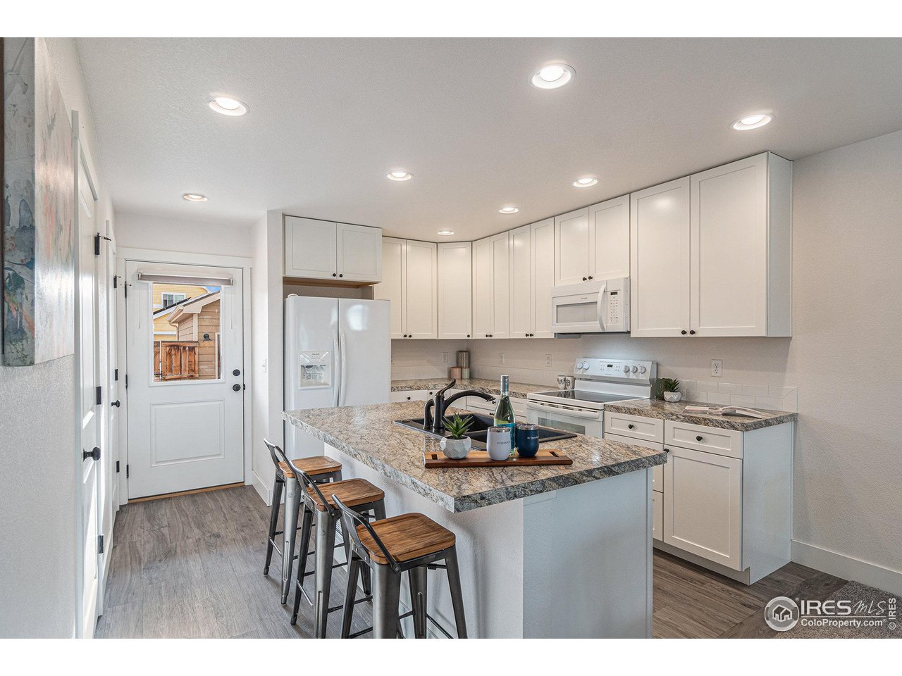 2771 Red Wheat Trail Berthoud, CO 80513 - Photo 9 of 24 a kitchen with a dining table chairs refrigerator and cabinets