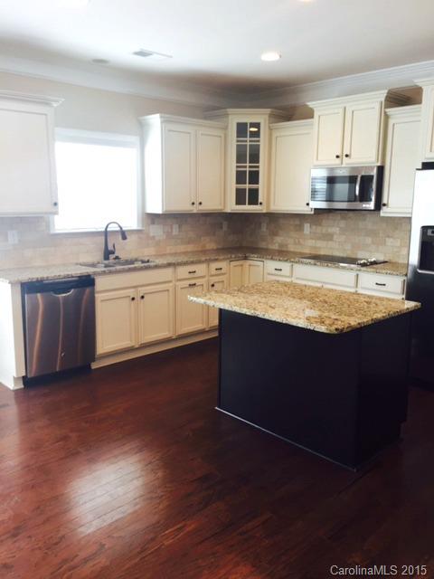 1834 Larkspur Way, Unit 203 Tega Cay, SC 29708 - Photo 5 of 24 a kitchen with stainless steel appliances granite countertop a sink dishwasher stove and cabinets with wooden floor