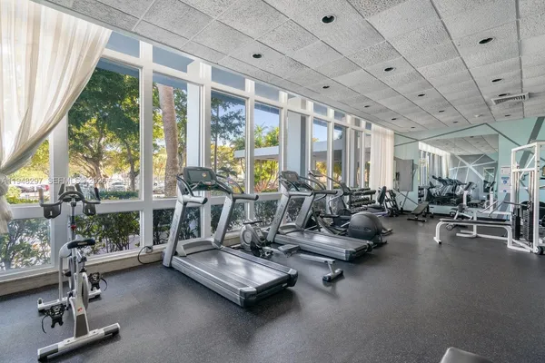 a room with gym equipment and large windows