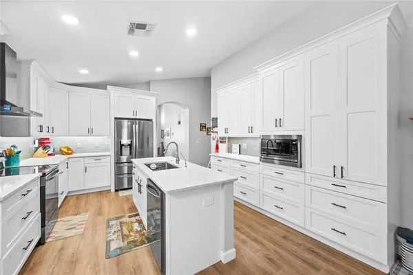 a kitchen with white cabinets and stainless steel appliances