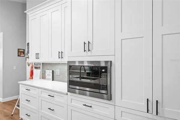 a kitchen with white cabinets and oven