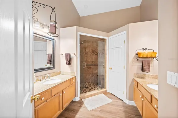 a bathroom with a double vanity sink a mirror and a shower
