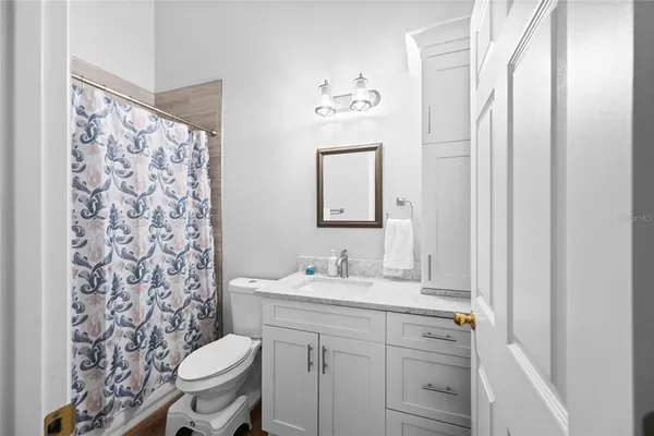 a bathroom with a sink a toilet and shower curtain