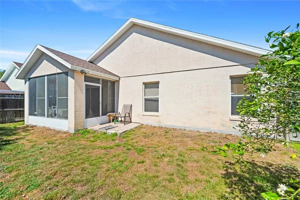 a view of house with backyard and glass windows