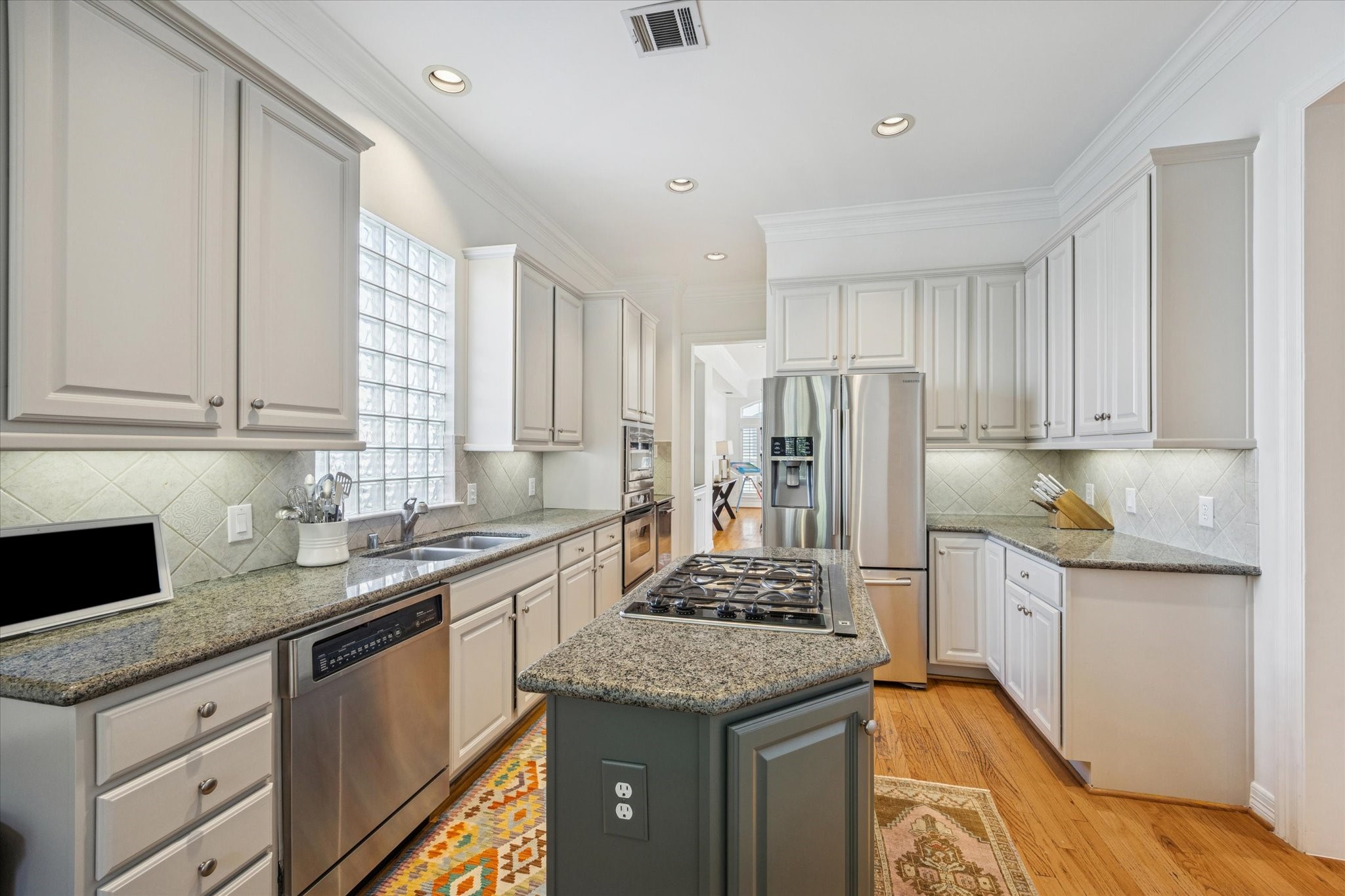 2700 Wroxton Road West University Place, TX 77005 - Photo 14 of 32 a kitchen with granite countertop stainless steel appliances a sink stove refrigerator and cabinets
