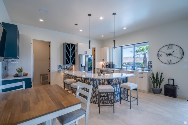 3606 South Cypress Road Hurricane, UT 84737 - Photo 59 of 69 Kitchen with a kitchen bar, light stone countertops, a peninsula, and decorative light fixtures
