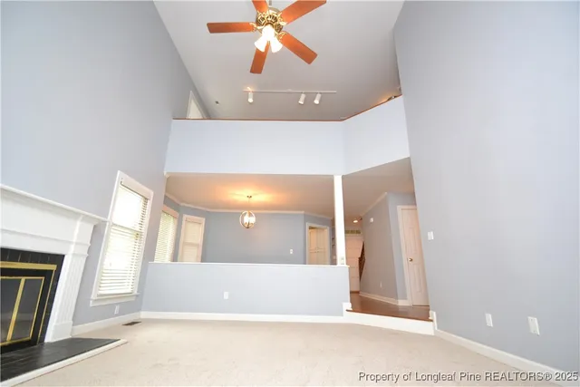 a view of a hallway with wooden floor and a bathroom