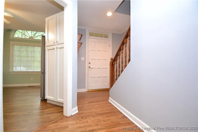a view of a hallway with wooden floor and staircase
