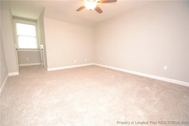 an empty room with a chandelier fan
