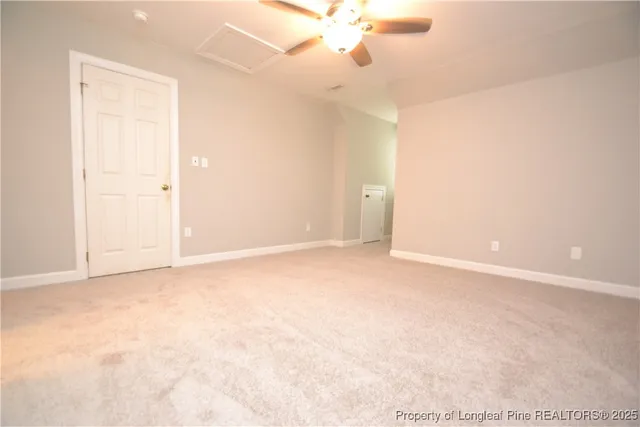 an empty room with a ceiling fan and window