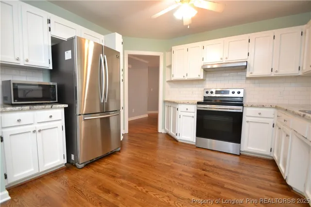 a kitchen with stainless steel appliances a stove a microwave and a refrigerator