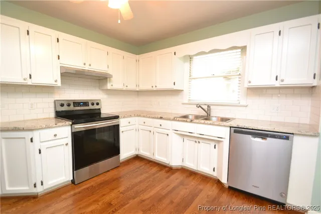 a kitchen with granite countertop white cabinets and white appliances