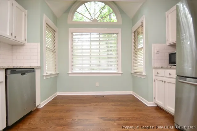 a view of a kitchen with wooden floor and a window