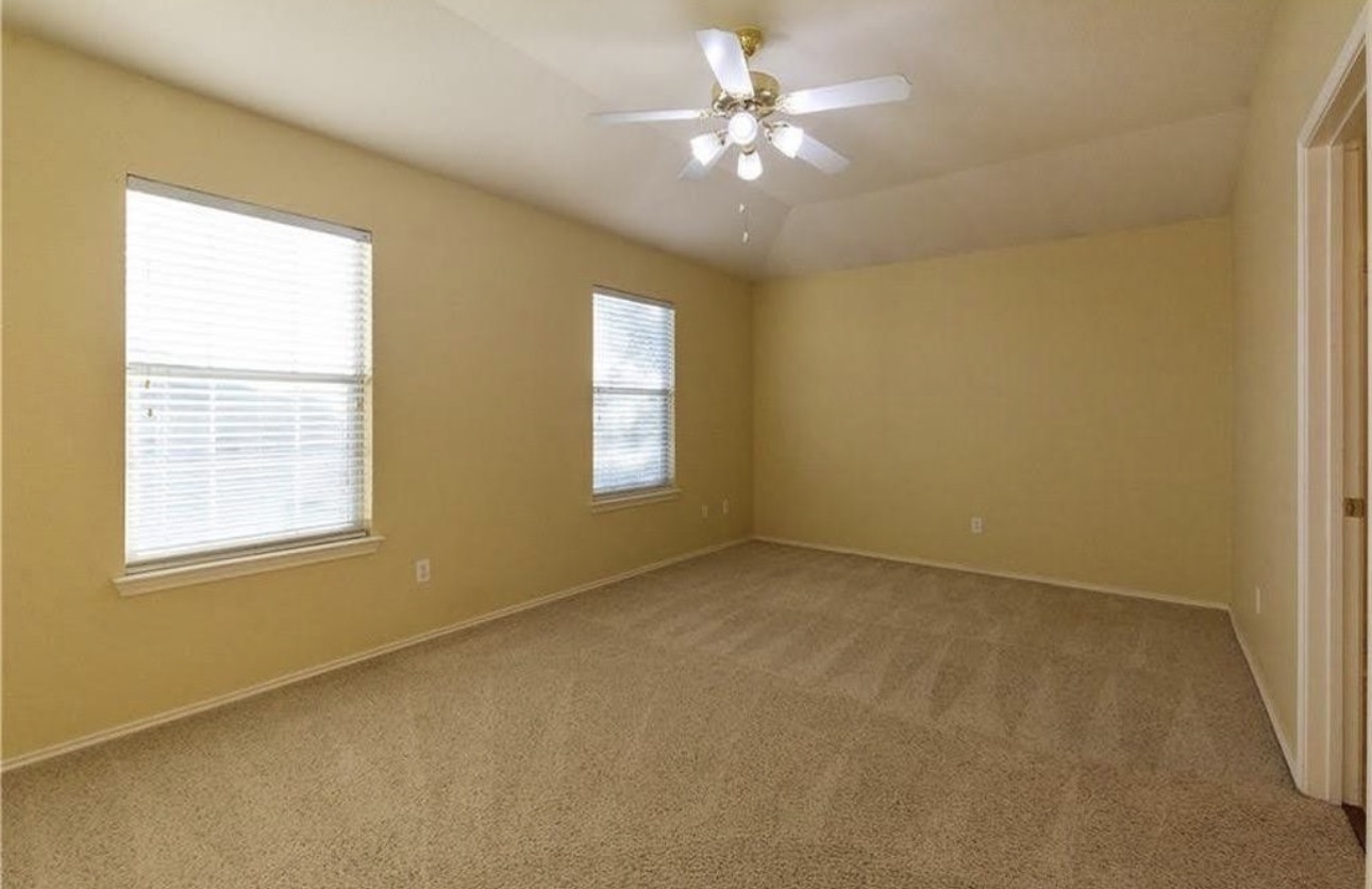 1900 Scofield Ridge Parkway, Unit 3101 Austin, TX 78727 - Photo 15 of 24 Spacious room featuring neutral carpeting, two windows with horizontal blinds, and a ceiling fan with integrated lighting