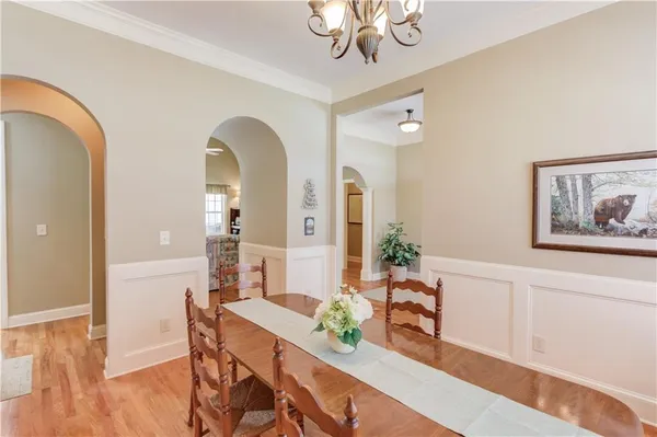a view of a dining room with furniture a chandelier and wooden floor