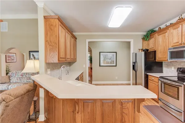 a kitchen with stainless steel appliances kitchen island granite countertop a sink a stove and refrigerator
