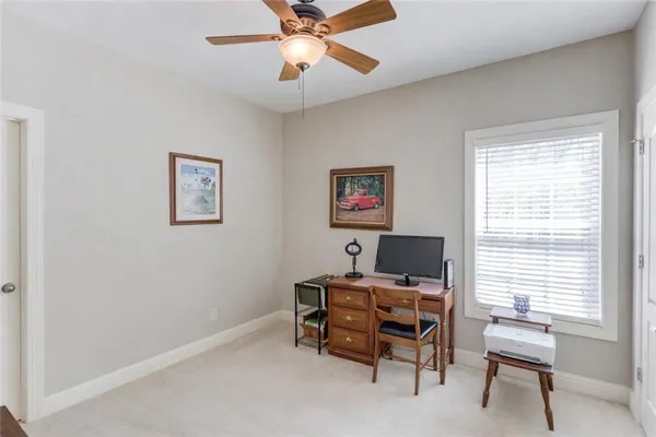 a view of a workspace with furniture and a window