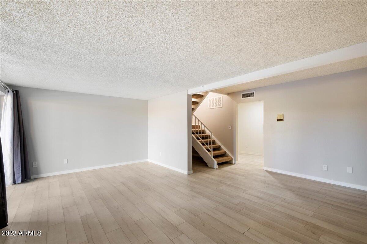 2524 South El Paradiso, Unit 50 Mesa, AZ 85202 - Photo 20 of 36 a view of an empty room with wooden floor and a ceiling fan