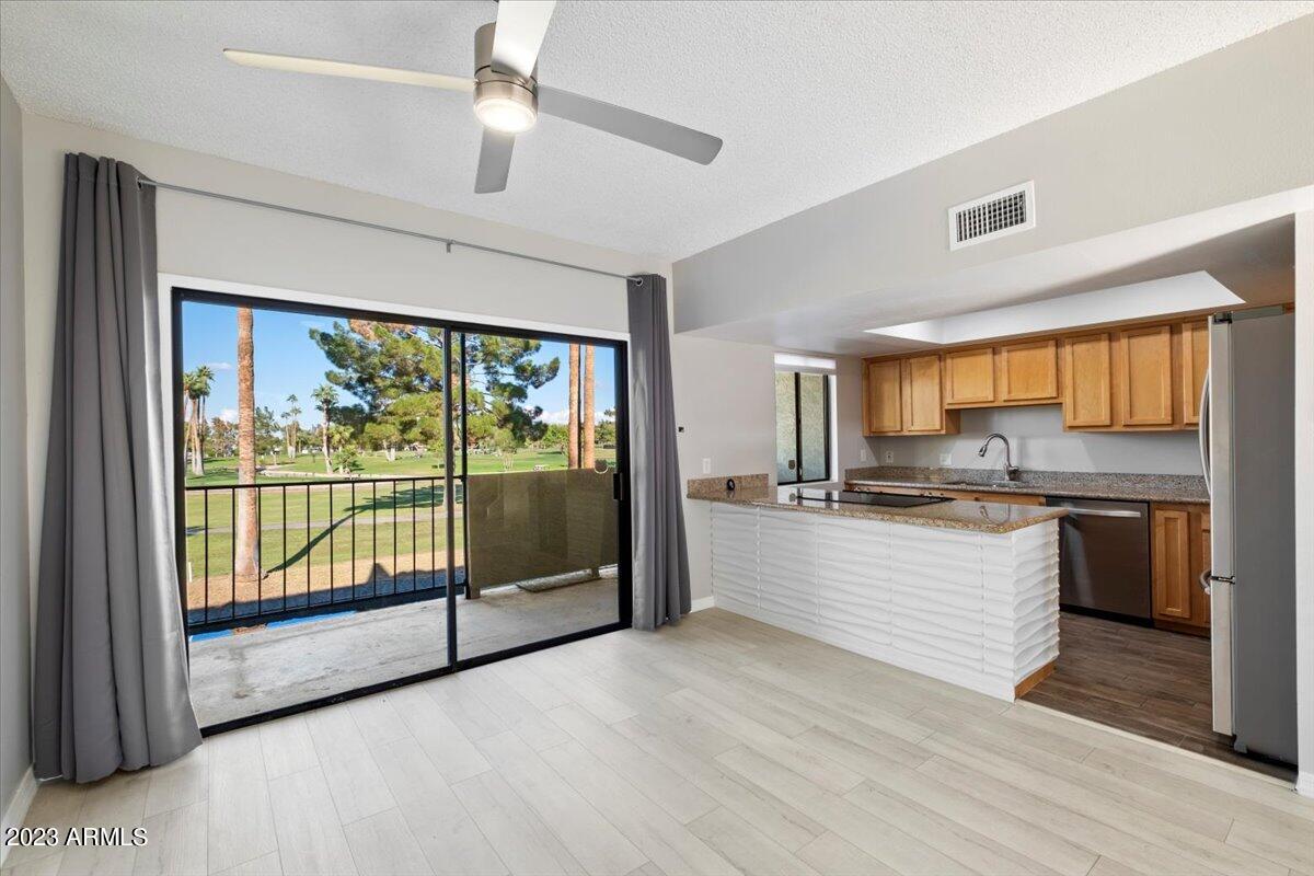 2524 South El Paradiso, Unit 50 Mesa, AZ 85202 - Photo 7 of 36 a large kitchen with kitchen island a large window a sink and stainless steel appliances