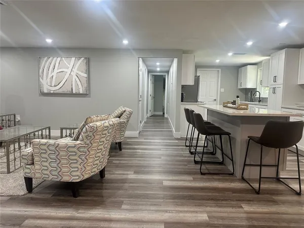 a living room with furniture and a wooden floor