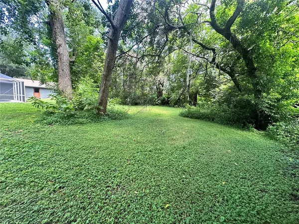 a view of a swimming pool with a yard and sitting area