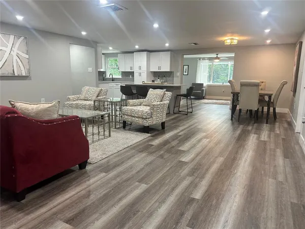 a living room with furniture and a wooden floor