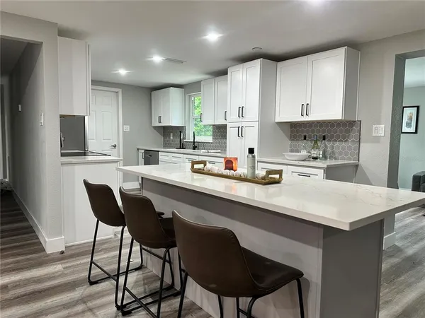 a kitchen with a dining table chairs and refrigerator