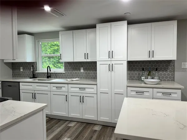 a kitchen with white cabinets and white appliances