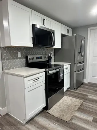 a kitchen with white cabinets and stainless steel appliances