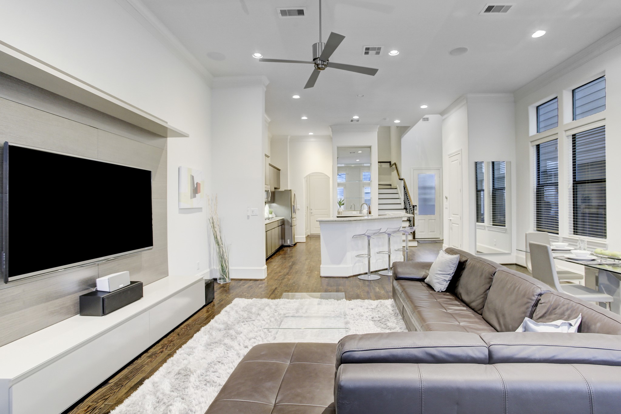 5506 Darling Street Houston, TX 77007 - Photo 6 of 23 Living Area with sizable TV, gleaming hardwood flooring, comfortable furnishings, recessed lighting & ceiling fan. Open to Kitchen and Dining Area.